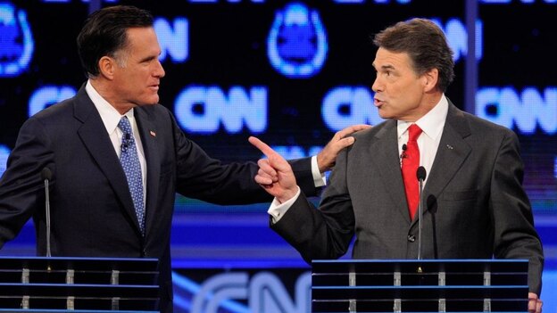Former Massachusetts Gov. Mitt Romney (left) and Texas Gov. Rick Perry got into a heated exchange about immigration during Tuesday's GOP presidential debate in Las Vegas.