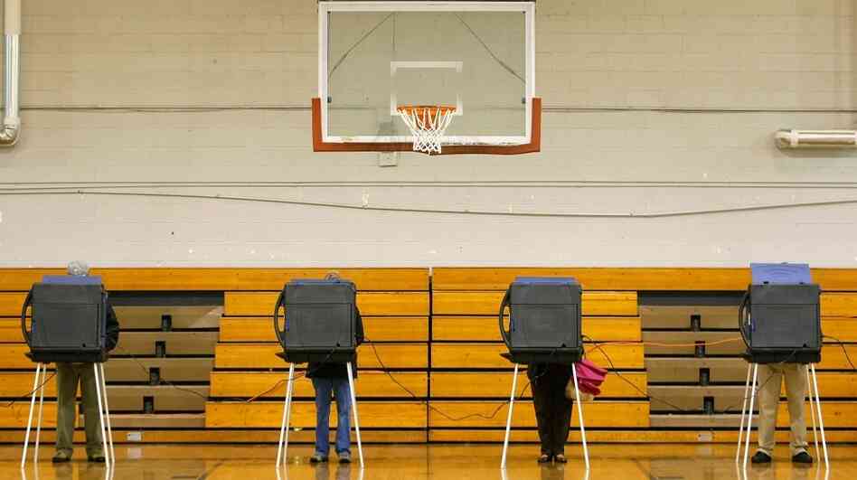Voters stand at the voting booths inside the gymnasium at West Ashley Middle School in Charleston, S.C., in January 2008. This year, South Carolina passed a law requiring voters to show a government-issued photo ID at the polls. It still needs approval from the U.S. Justice Department, but it has voting rights advocates worried. Voters stand at the voting booths inside the gymnasium at West Ashley Middle School in Charleston, S.C., in January 2008. This year, South Carolina passed a law requiring voters to show a government-issued photo ID at the polls. It still needs approval from the U.S. Justice Department, but it has voting rights advocates worried.