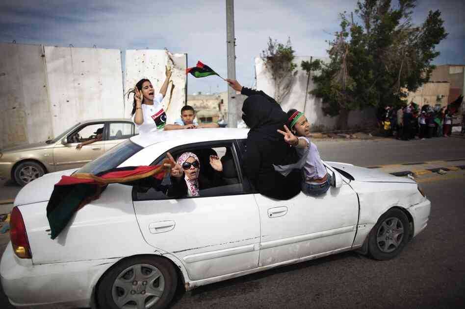 Libyan women and children wave NTC flags as they celebrate in the streets of Tripoli following news of Moammar Gadhafi's death. 