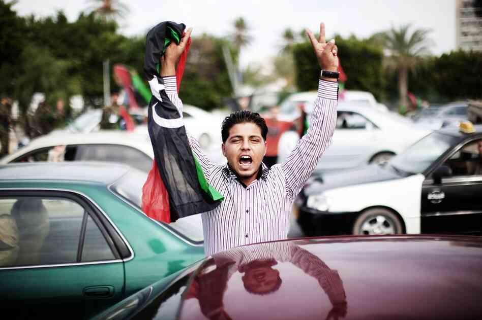 A Libyan youth holds a NTC flag during celebrations in the streets of Tripoli.  