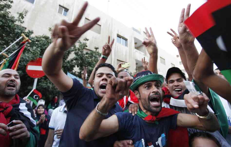 Libyans celebrate Moammar Gadhafi's death in front of the Libyan Embassy in Amman, Jordan, on Thursday. 