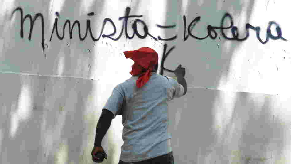 A Haitian protester in Port-au-Prince last month spray-paints a wall, equating the UN mission in Haiti (abbreviated here as MINISTA) with cholera. 