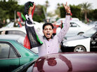 A Libyan youth holds a National Transitional Council (NTC) flag during celebrations in the streets of Tripoli following news of Moammar Gadhafi's capture on October 20, 2011. A Libyan youth holds a National Transitional Council (NTC) flag during celebrations in the streets of Tripoli following news of Moammar Gadhafi's capture on October 20, 2011.