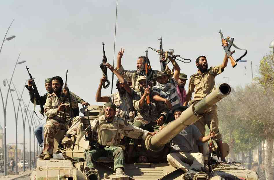 Anti-Gadhafi fighters celebrate the fall of Sirte. Libyan interim government fighters captured Moammar Gadhafi's hometown on Thursday. 