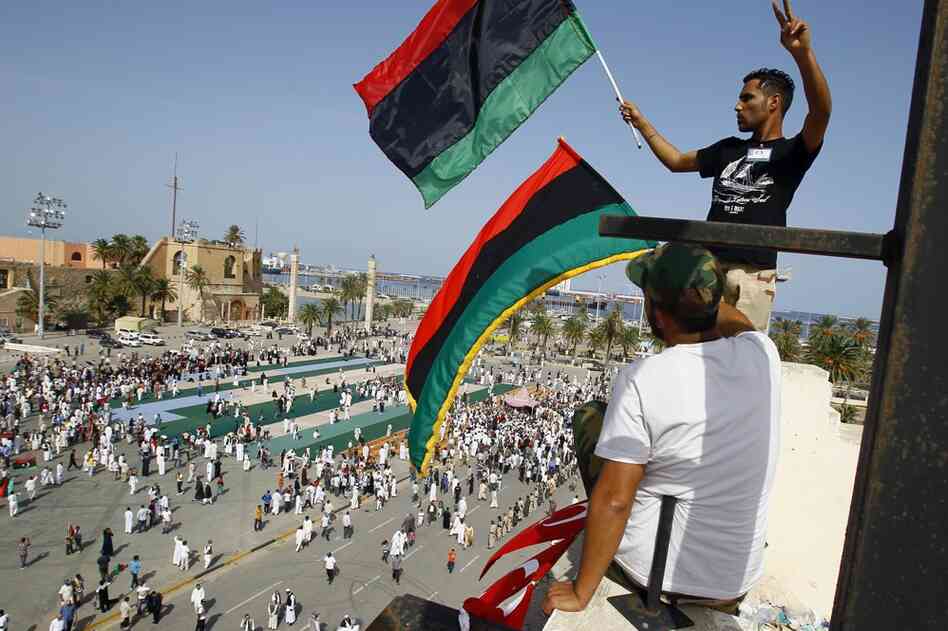 Men wave a Libyan flag after Friday prayer at Martyrs Square in Tripoli. 