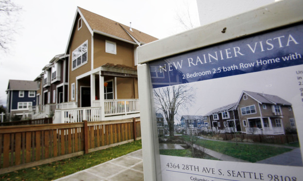 A home in Seattle is advertised for sale in January. A housing boom 140 miles north in Vancouver, British Columbia, is being fueled by buyers from India and China, while building remains at a standstill in Seattle, one housing expert says.
