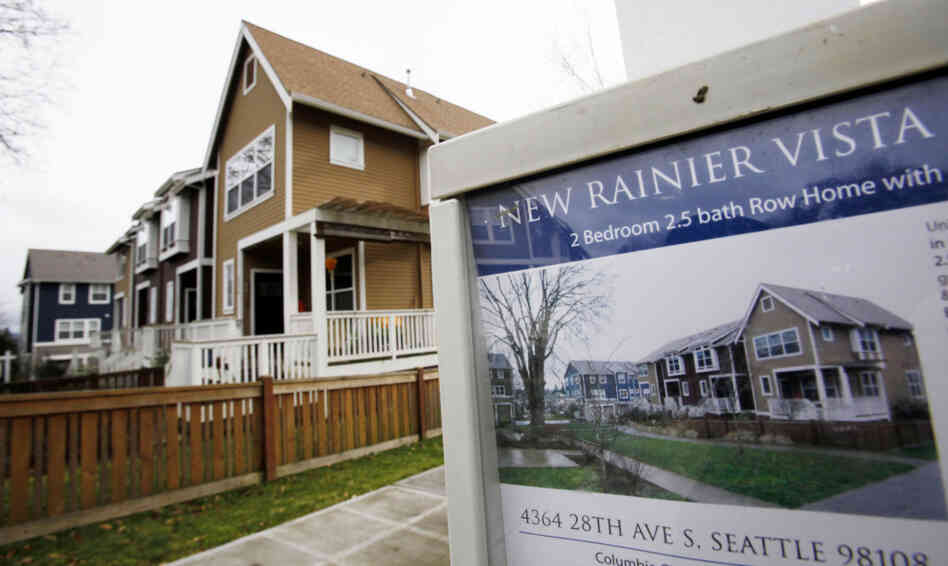 A home in Seattle is advertised for sale in January. A housing boom 140 miles north in Vancouver, British Columbia, is being fueled by buyers from India and China, while building remains at a standstill in Seattle, one housing expert says.