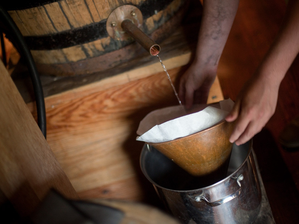 In a cavernous barn, distillers make whiskey with rye, corn and malted barley.