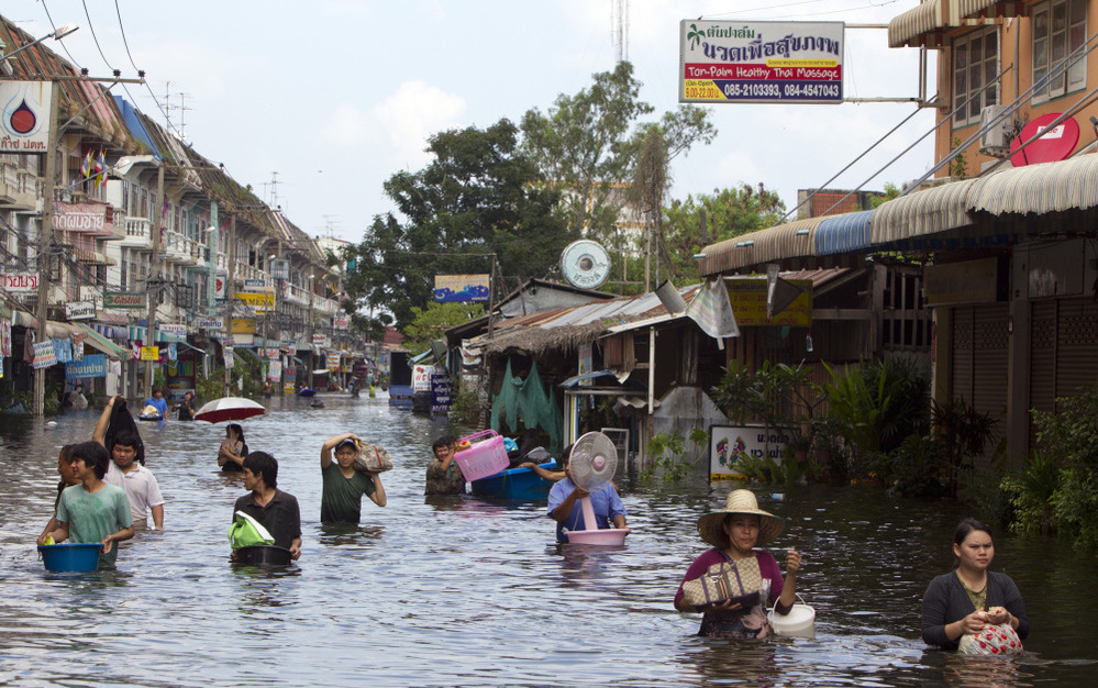 Residents make their way along flooded streets on the outskirts of Bangkok on Saturday. Thailand is experiencing the worst flooding in 50 years.