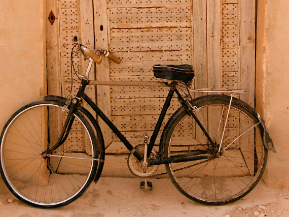 <p>A bicycle parked against a doorway.</p>