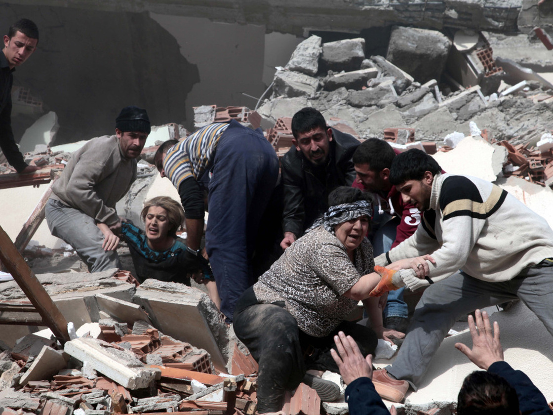 People rescue two women trapped under debris in Van eastsern Turkey after a powerful 7.2-magnitude earthquake struck eastern Turkey, collapsing about 45 buildings in Van province Sunday.