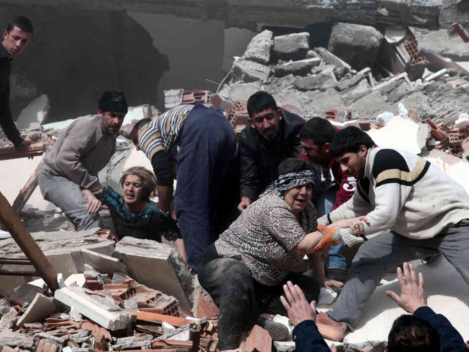 People rescue two women trapped under debris in Van eastsern Turkey after a powerful 7.2-magnitude earthquake struck eastern Turkey, collapsing about 45 buildings in Van province Sunday.