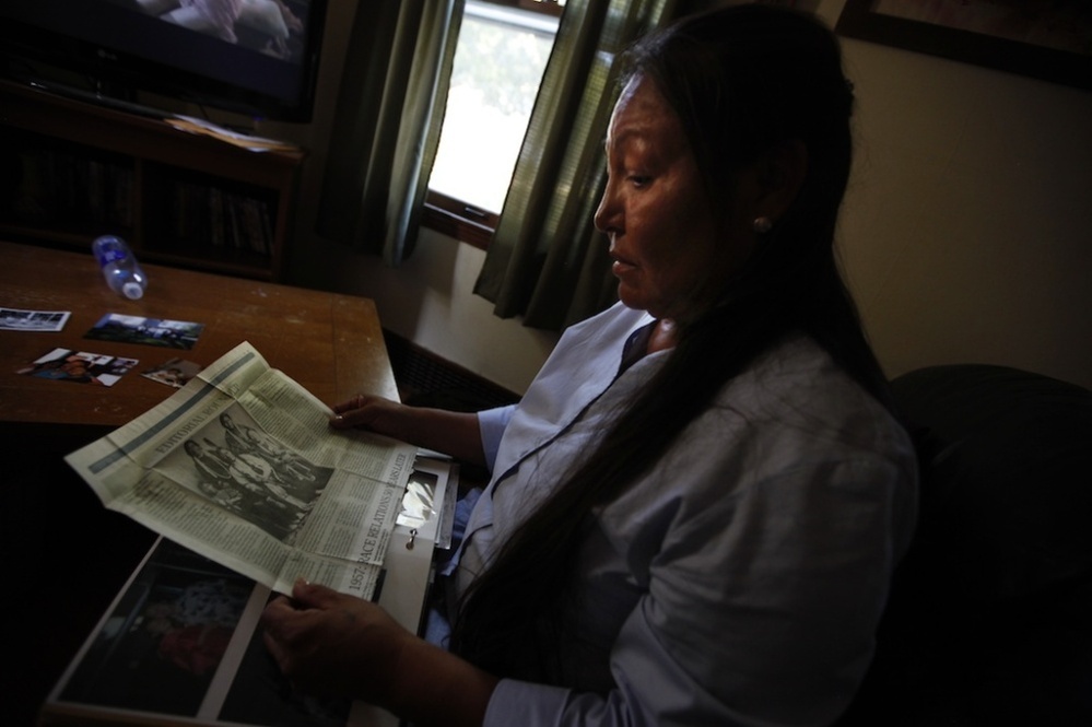 Suzanne Crow looks through a family photo album at her home in Sioux Falls, S.D., and comes across an old newspaper clipping of Sitting Bull, a Hunkpapa Lakota like herself.