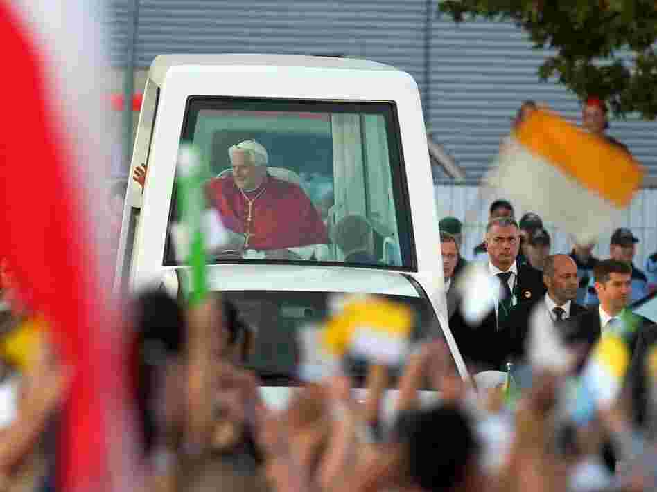 Pope Benedict XVI rides in his popemobile through Freiburg im Breisgau, Germany, last month. The Vatican has released a document on world economics, condemning "idolatry of the market."