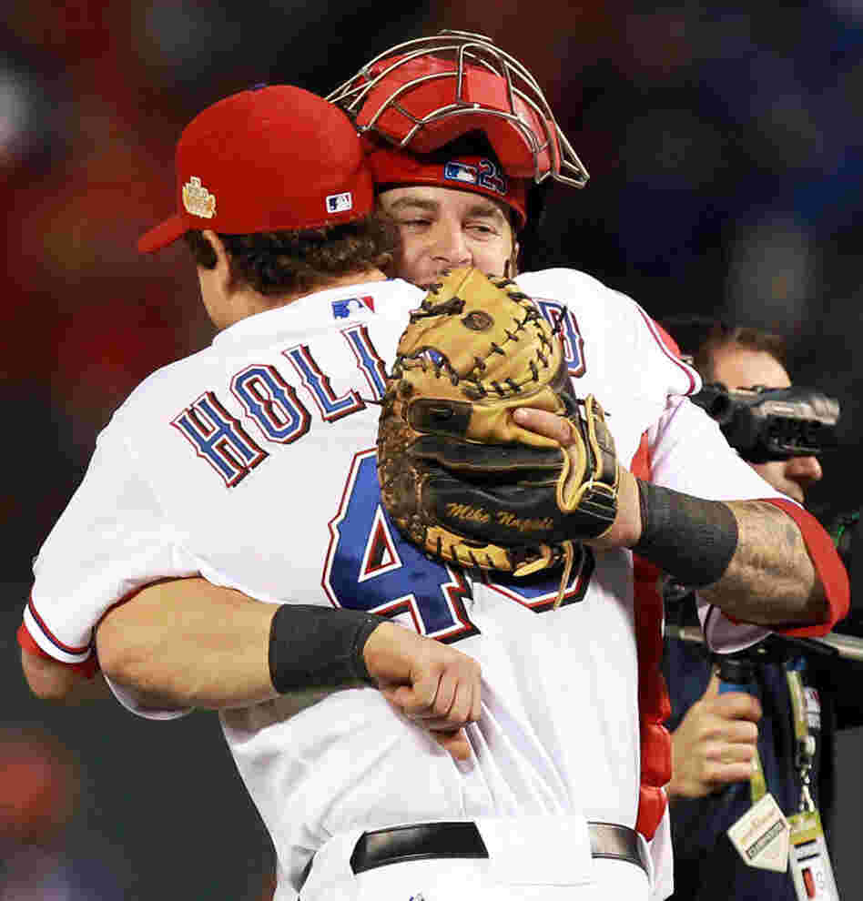 Texas Rangers pitcher Derek Holland and catcher Mike Napoli celebrate after defeating the St. Louis Cardinals 4-0 in game four of the MLB World Series.