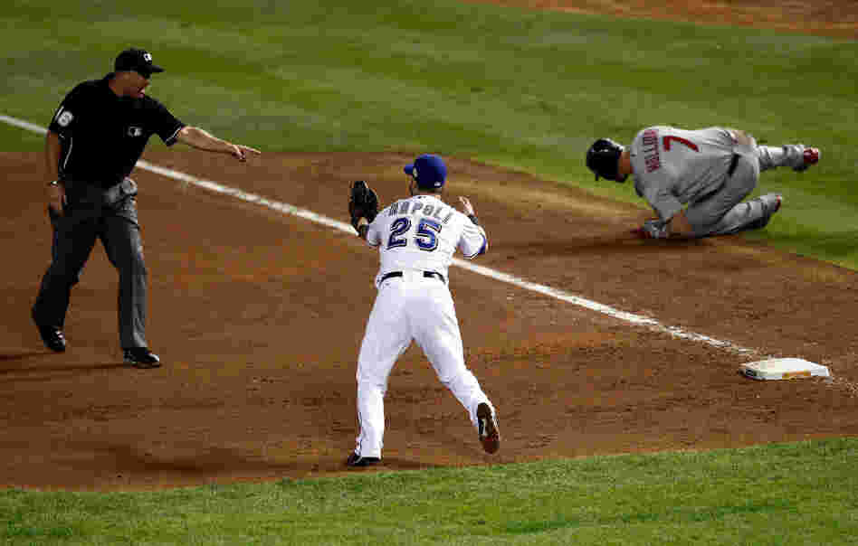 Mike Napoli of the Texas Rangers reacts after first base umpire Ron Kulpa calls Matt Holliday of the St. Louis Cardinals safe in the fourth inning of game three of the World Series.