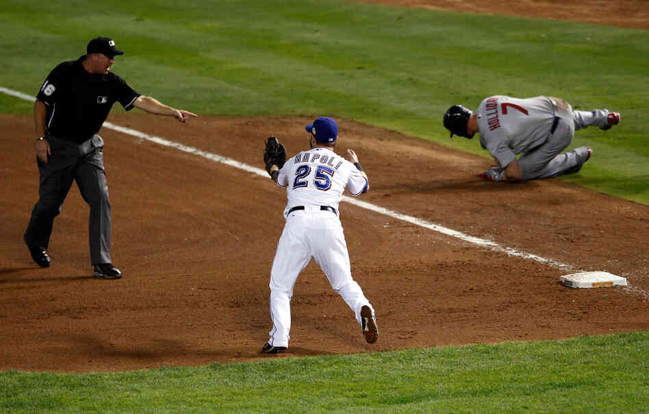 Mike Napoli of the Texas Rangers reacts after first base umpire Ron Kulpa calls Matt Holliday of the St. Louis Cardinals safe in the fourth inning of game three of the World Series.