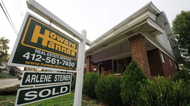 In this Oct. 18, 2011 photo, a "sale pending" sign hangs in the yard of a home in Mount Lebanon, Pa. 