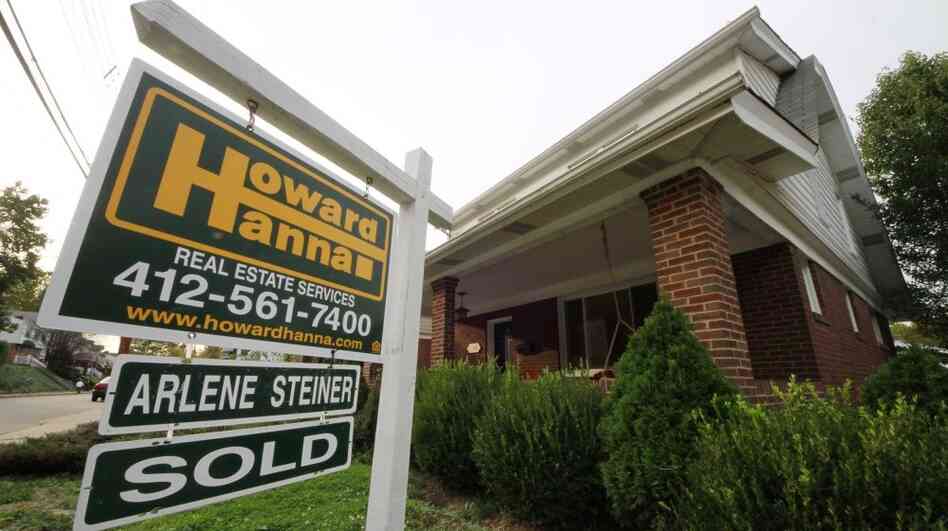 In this Oct. 18, 2011 photo, a "sale pending" sign hangs in the yard of a home in Mount Lebanon, Pa. 