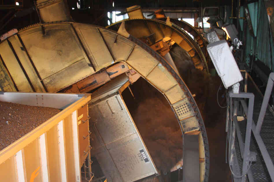 It's a dirty operation: As the train cars snake through a building, a large machine called a "double dumper" tips over and empties the coal, two cars at a time. 