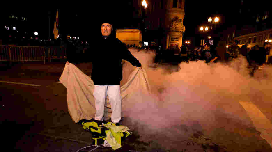 An Occupy Oakland protester stands with a banner after police used tear gas to disperse a large crowd Tuesday (Oct. 25, 2011). 
