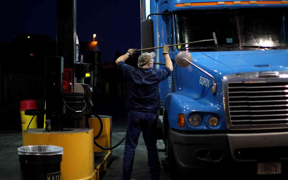 A truck driver cleans his windshield at a filling station in Milford, Conn. The long hours, weeks away from home and mediocre pay contribute to the trucking industry's shortage of an estimated 125,000 drivers. A truck driver cleans his windshield at a filling station in Milford, Conn. The long hours, weeks away from home and mediocre pay contribute to the trucking industry's shortage of an estimated 125,000 drivers.