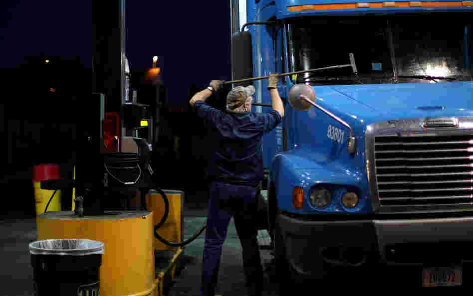 A truck driver cleans his windshield at a filling station in Milford, Conn. The long hours, weeks away from home and mediocre pay contribute to the trucking industry's shortage of an estimated 125,000 drivers. A truck driver cleans his windshield at a filling station in Milford, Conn. The long hours, weeks away from home and mediocre pay contribute to the trucking industry's shortage of an estimated 125,000 drivers.