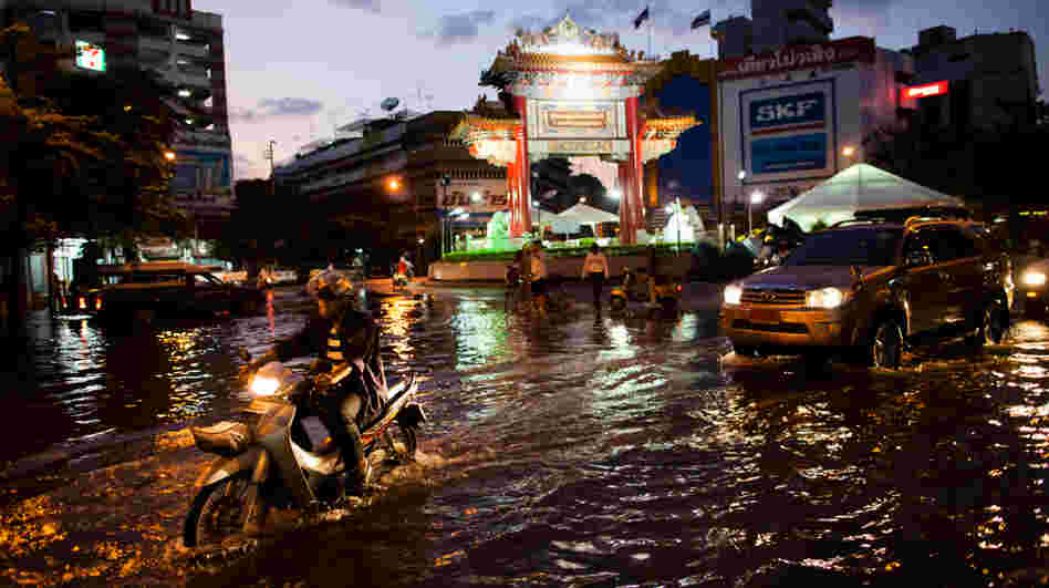 Residents drive through a flooded street close to the overflowing Chao Phraya river in Bangkok on Thursday. About 400 people have died from floods in the country since late July. Residents drive through a flooded street close to the overflowing Chao Phraya river in Bangkok on Thursday. About 400 people have died from floods in the country since late July.