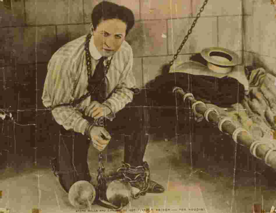 Harry Houdini started performing as a professional magician in the U.S. in 1891. The caption at the bottom of this photo reads: "Stone walls and chains do not make a prison — for Houdini." 