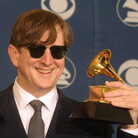 T Bone Burnett holds two trophies, one for Producer of the Year, at the Grammy Awards in 2002. T Bone Burnett holds two trophies, one for Producer of the Year, at the Grammy Awards in 2002.