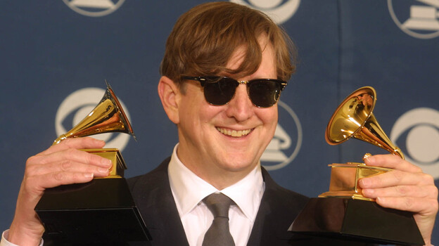 T Bone Burnett holds two trophies, one for Producer of the Year, at the Grammy Awards in 2002.