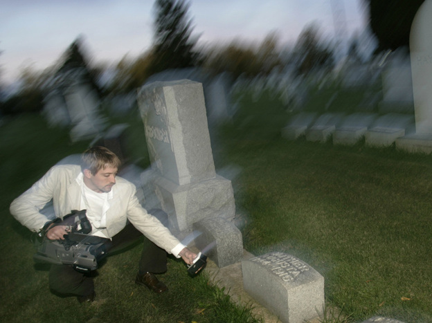 Paranormal investigator Noah Voss points a video camera at an electromagnetic frequency device to record any abnormal activity at the Sun Prairie Cemetery in Sun Prairie, Wis.