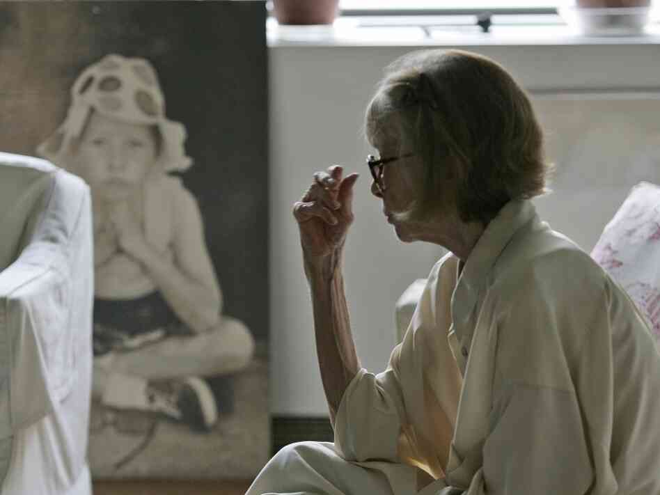 Didion looks at a painting of her daughter in her New York apartment.