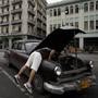 A man checks his car in Havana. In October, Cuba legalized the sale and purchase of automobiles for all citizens. Now, Cubans who leave the island permanently can transfer ownership of their car to a relative or sell it outright. Previously, Cuba could seize the vehicles of those who emigrated. 