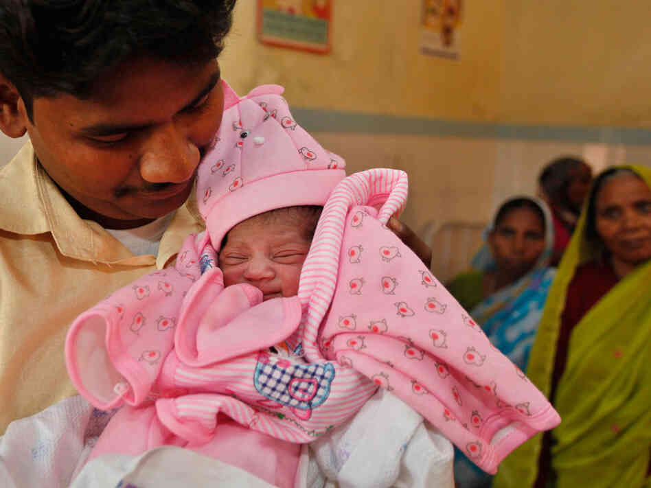 Father of Nargis, a symbolic 7 billionth baby, looks at his daughter at the Community Health Center in Mall, about 28 miles from Lucknow, India's most populous state of Uttar Pradesh, India, Father of Nargis, a symbolic 7 billionth baby, looks at his daughter at the Community Health Center in Mall, about 28 miles from Lucknow, India's most populous state of Uttar Pradesh, India,