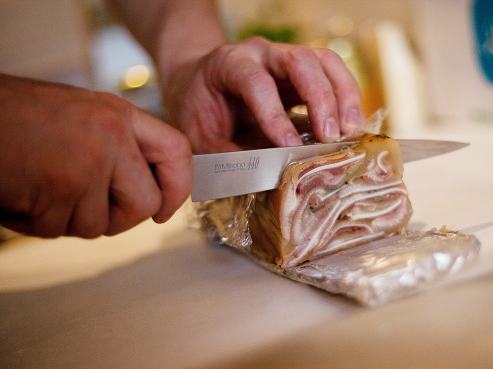 Chef Daniel O'Brien slices the pig ear terrine he made for the "Scary Bits" dinner at his Season Pantry supper club in Washington, D.C.