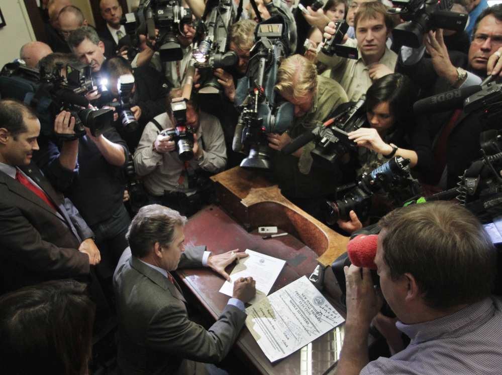 Texas Gov. Rick Perry fills out his papers to be on the New Hampshire's presidential primary ballot, Friday, Oct. 28, 2011.