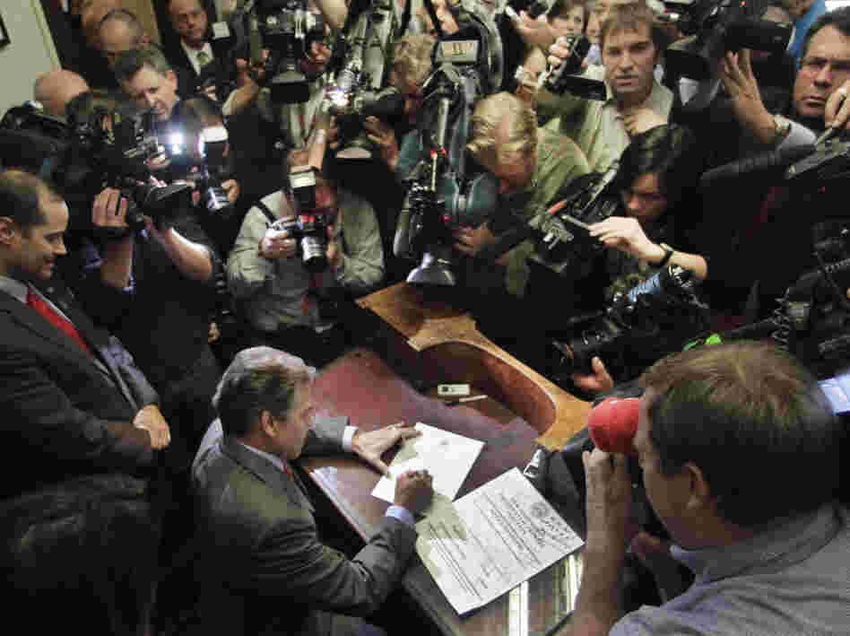 Texas Gov. Rick Perry fills out his papers to be on the New Hampshire's presidential primary ballot, Friday, Oct. 28, 2011.