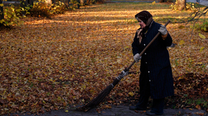 An elderly woman rakes leaves in Kaliningrad, Russia. Since 1992, the number of deaths in the country has outpaced births by nearly 3 to 2.