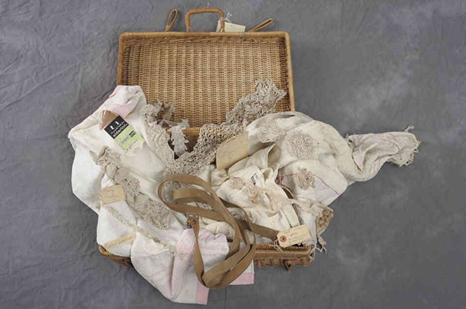 A wicker suitcase belonging to Mary Watson contains fabrics and lace.