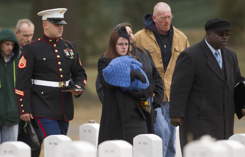 Kait Wyatt carries her 1-month-old son, Michael, at the burial for her husband, Marine Cpl. Derek Wyatt, at Arlington National Cemetery, Jan. 7. Wyatt was killed Dec. 6, 2010, in Afghanistan. Kait Wyatt, who was pregnant at the time of her husband's death, was induced the day after he was killed so she could attend the service.