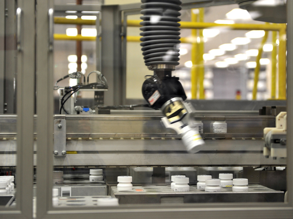 An automated robot arm picks up a bottle of prescription pills in the Medco pharmacy plant in Willingboro, N.J. Medco's state-of-the-art automated pharmacy can dispense up to 1 million prescriptions a week.