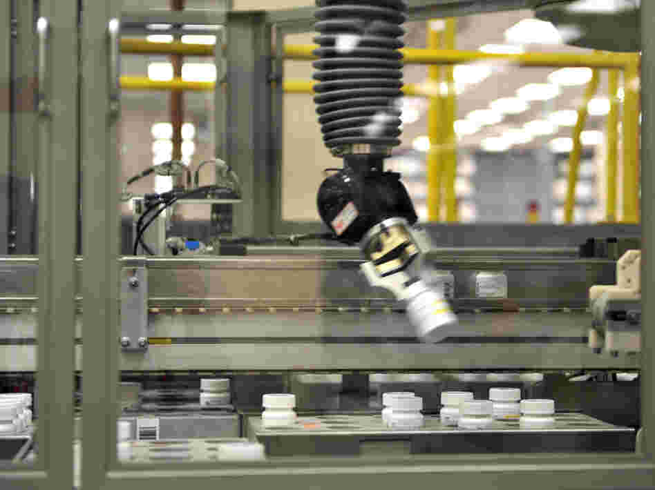 An automated robot arm picks up a bottle of prescription pills in the Medco pharmacy plant in Willingboro, N.J. Medco's state-of-the-art automated pharmacy can dispense up to 1 million prescriptions a week.