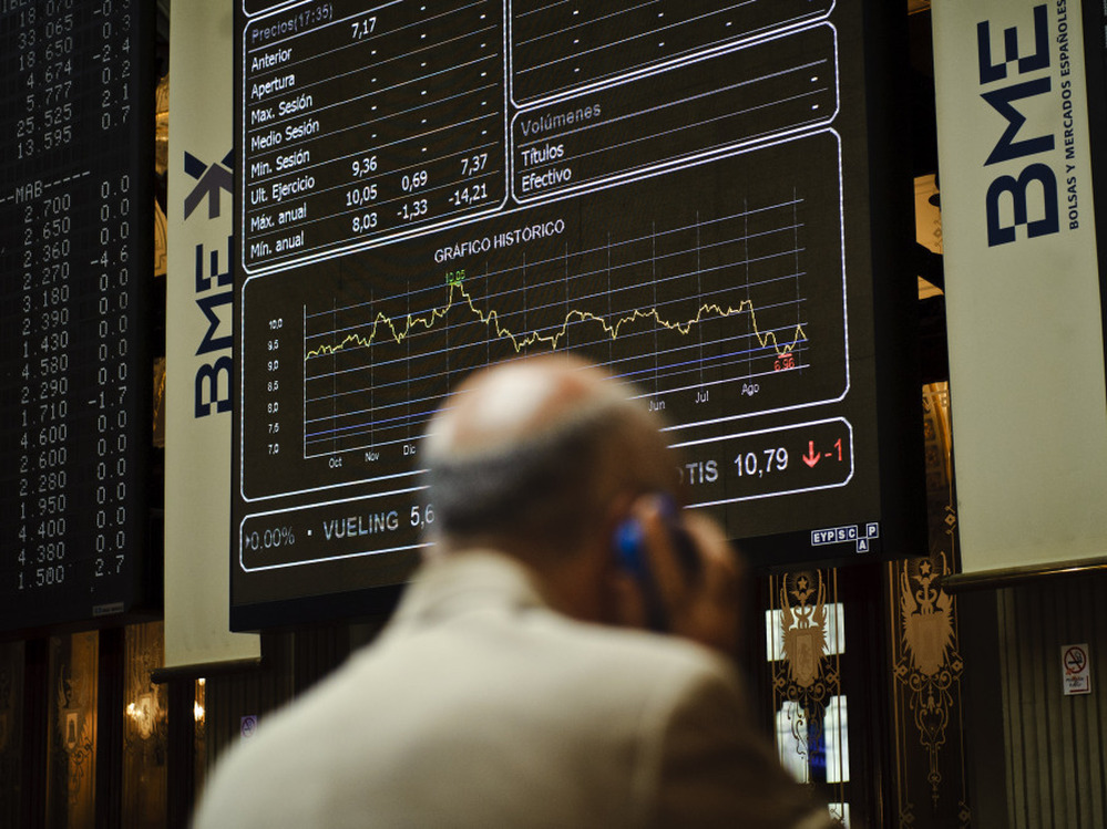 A broker uses a phone in front of the main screen at the Stock Exchange in Madrid, Spain. The country's central bank recently warned of "troubled exposure" to real estate, heightening fears about the stability of Spain's banks.