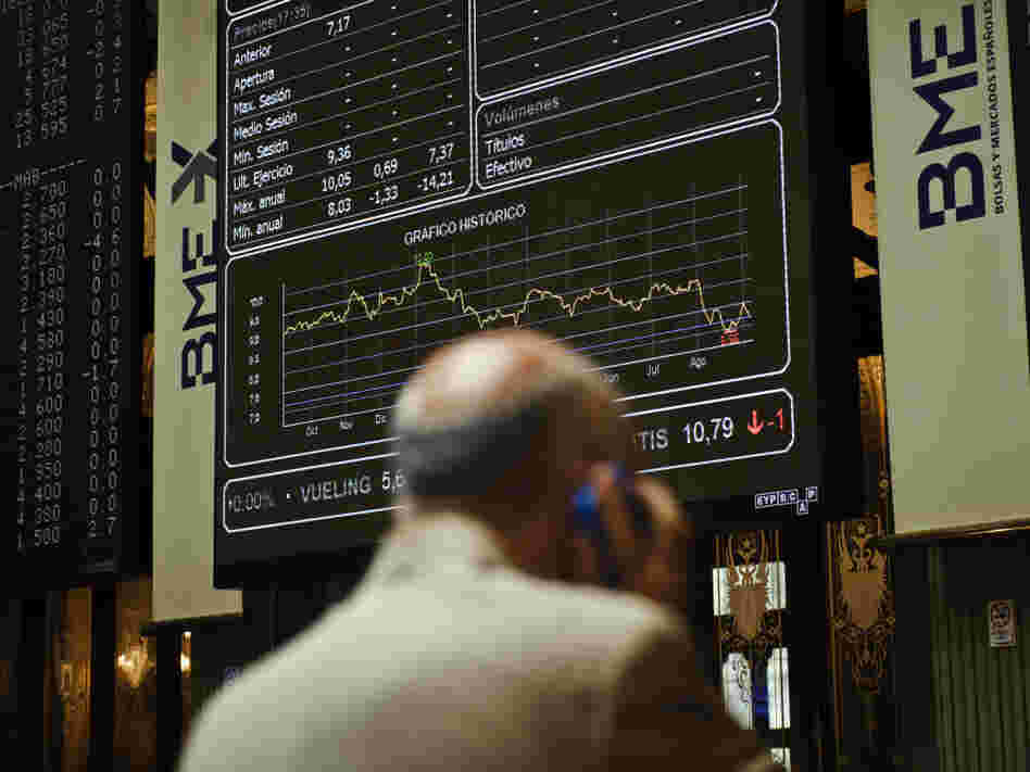 A broker uses a phone in front of the main screen at the Stock Exchange in Madrid, Spain. The country's central bank recently warned of "troubled exposure" to real estate, heightening fears about the stability of Spain's banks.