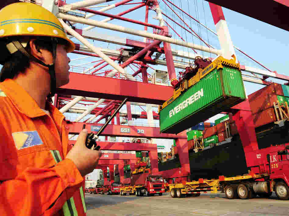 A worker monitors the loading of containers on to a ship at a harbor in China's Shandong province. Under a new U.S. law, Chinese food exporters will now have to share more food safety information with American food importers.