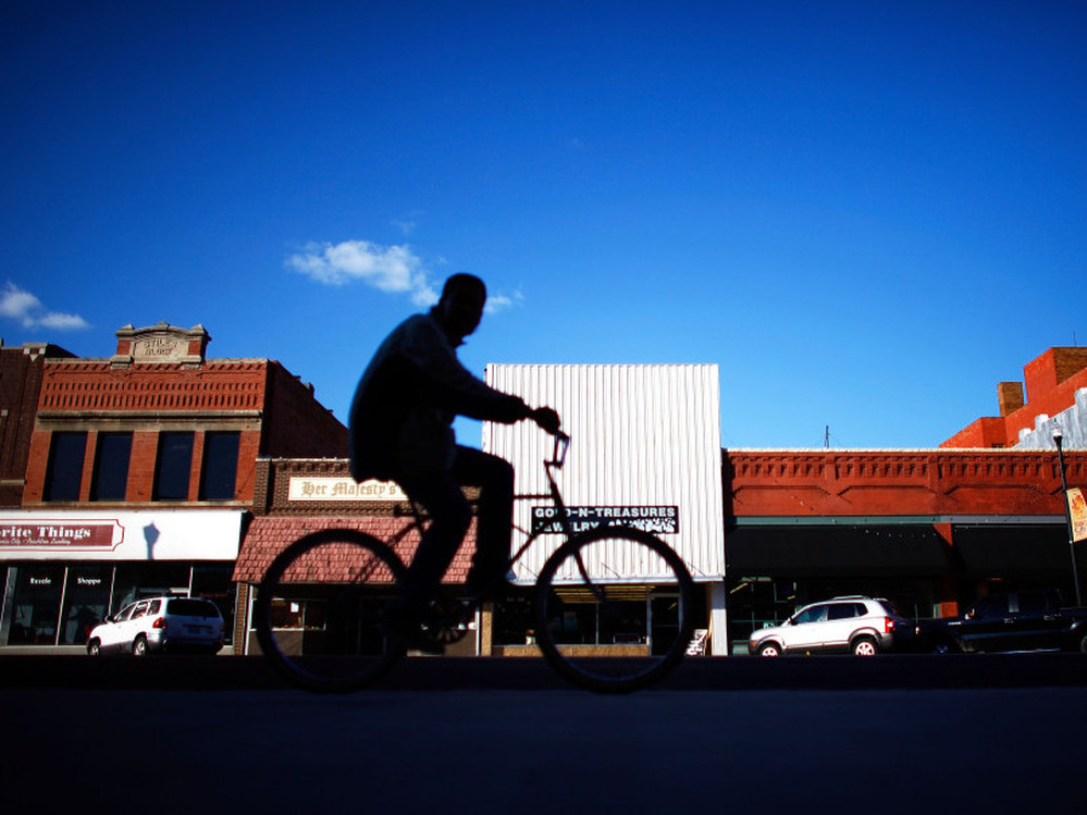 A biker rides through downtown Ponca City, Okla. After 726 complaints and close to $20 million in settled lawsuits against Continental Carbon, there are very few reports of black dust tainting the town.