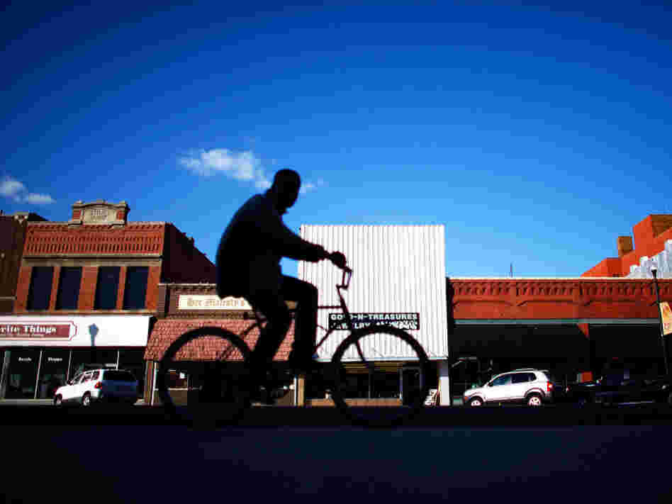A biker rides through downtown Ponca City, Okla. After 726 complaints and close to $20 million in settled lawsuits against Continental Carbon, there are very few reports of black dust tainting the town.