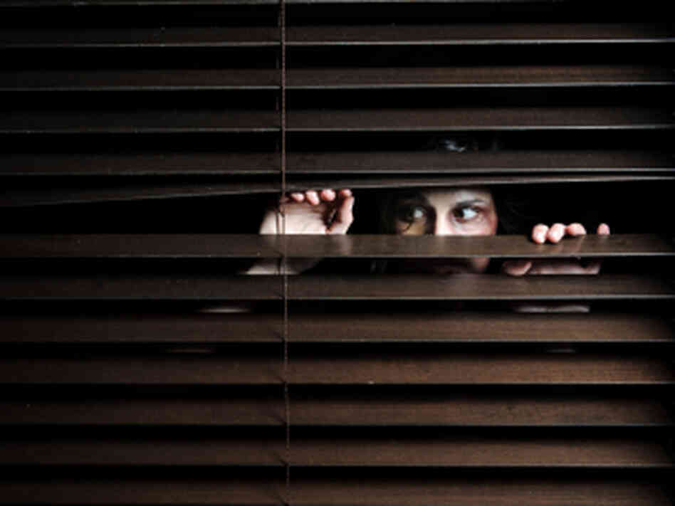 A woman looking through blinds. iStockphoto.com A woman looking through blinds. iStockphoto.com
