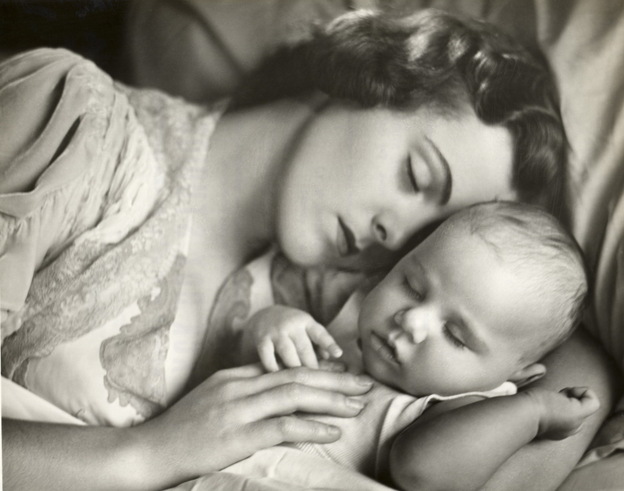 A 1950s photo of a mother and child sleeping in bed.